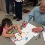 Retired Volunteer coloring with child